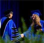 A graduate shakes President Mantella's hand during Commencement.